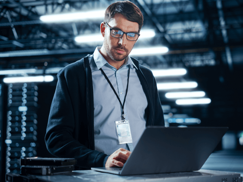 Man working on a laptop in a data center